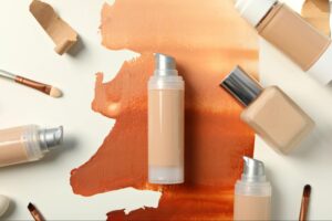 Artistic display of foundation bottles and brushes with shades for all skin tones.
