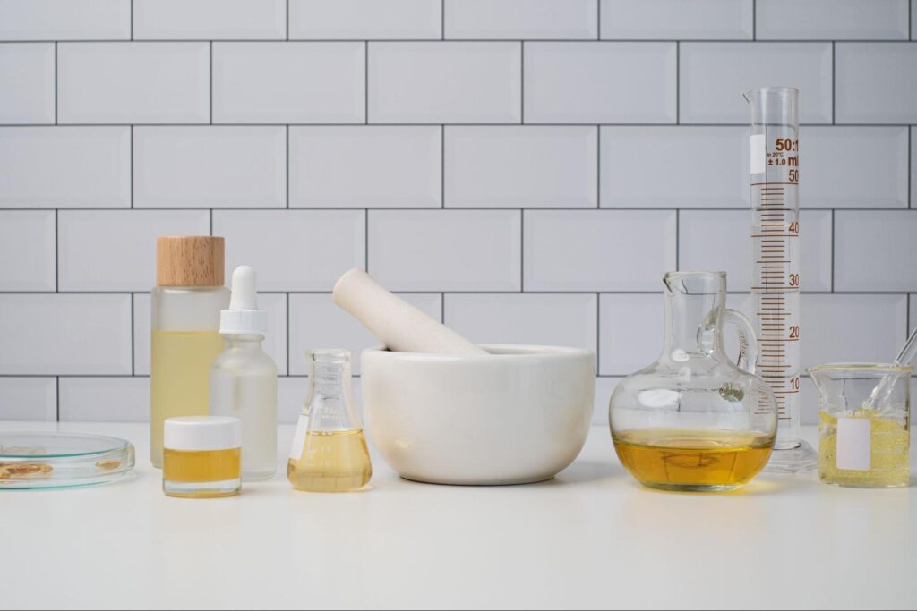 Natural beauty ingredients in a sleek modern lab setup with glass containers and tools.