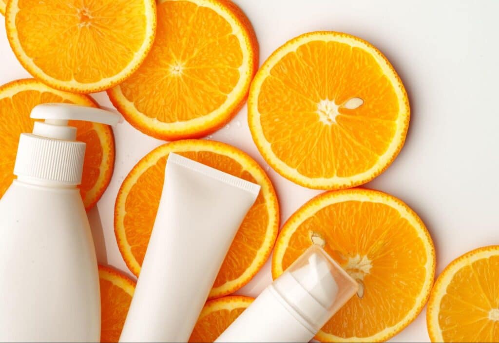 Refreshing skincare products surrounded by vibrant orange slices for a citrus-infused glow.
