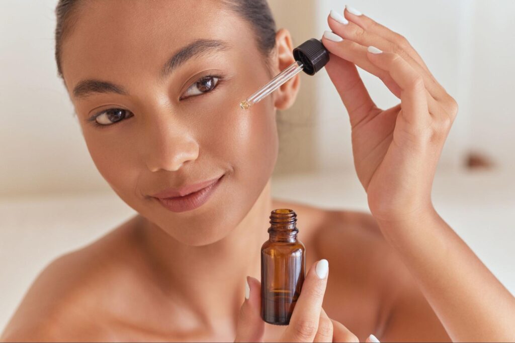Woman applying glowing skin serum for a radiant skincare routine.