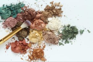 Vibrant cosmetic powders and brushes for artistic makeup application.
