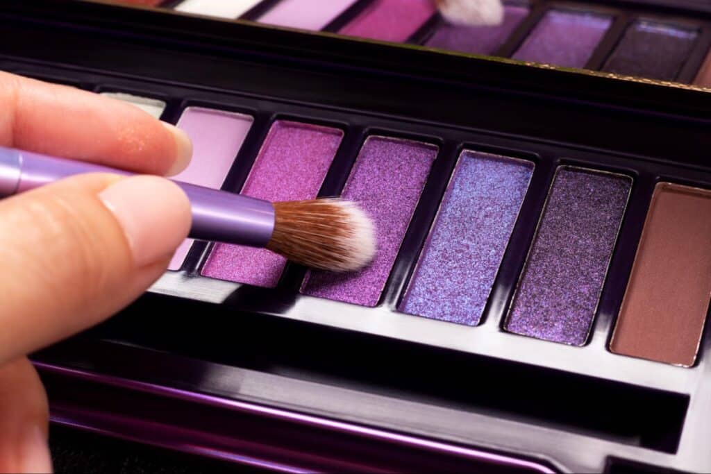 Purple eyeshadow palette with a brush for creating stunning, vibrant makeup looks.