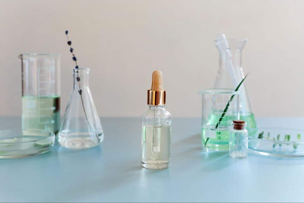Natural skincare serum featuring botanical ingredients and glass lab beakers.