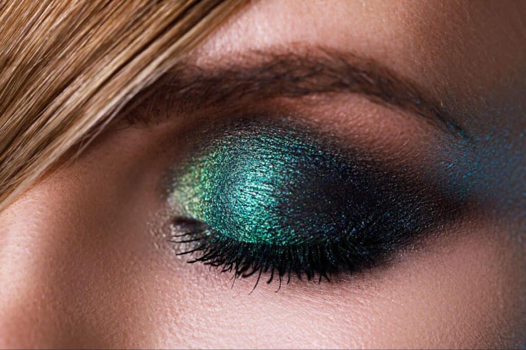 Bold green eyeshadow with deep black for striking makeup artistry.